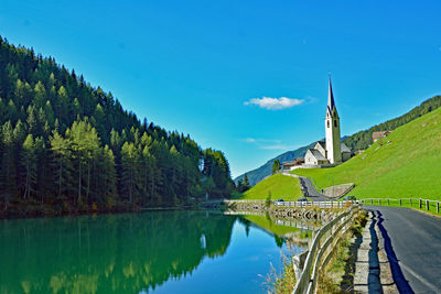 Scenic view of lake by trees against blue sky