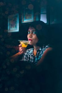Portrait of young woman drinking glass