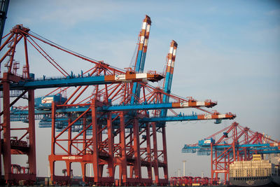 Cranes at construction site against sky