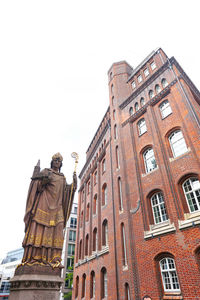 Low angle view of statue against building against clear sky