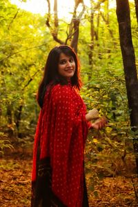 Portrait of smiling young woman in forest