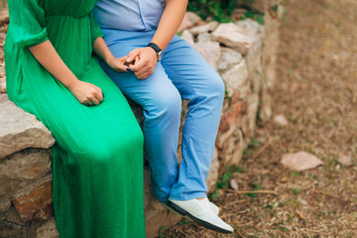 Low section of couple sitting outdoors