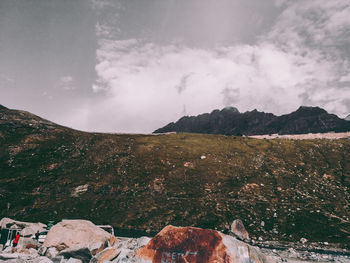 Scenic view of land and mountains against sky