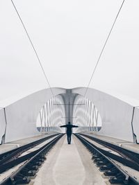 Rear view of man standing on railway track