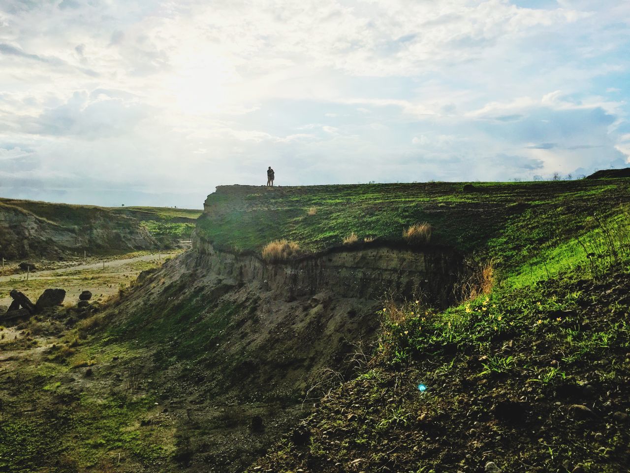 sky, tranquil scene, tranquility, landscape, scenics, nature, beauty in nature, cloud - sky, grass, mountain, non-urban scene, cloud, remote, rock - object, cloudy, rock formation, idyllic, hill, day, cliff