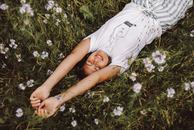High angle view of young woman lying down on grass