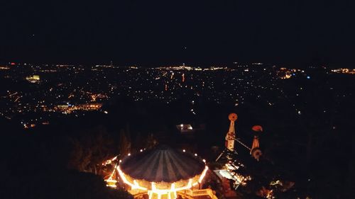 Illuminated cityscape against sky at night
