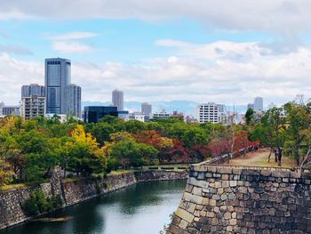 River amidst trees and buildings against sky