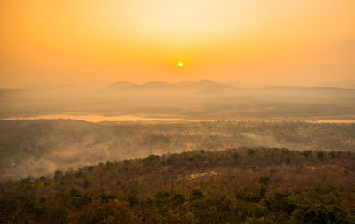 Scenic view of landscape against orange sky