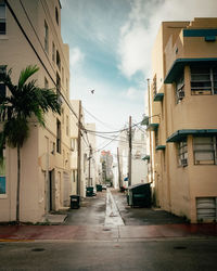 Empty road amidst buildings against sky