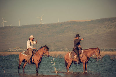 Men riding horse cart on land