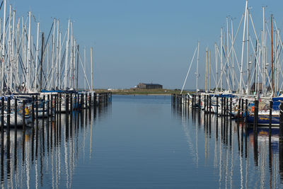 Sailboats moored in sea against clear sky