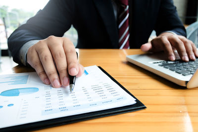 Midsection of man with text on table
