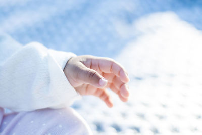 Close-up of woman hand against sky