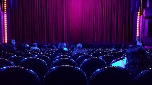 People sitting on seats at theatre