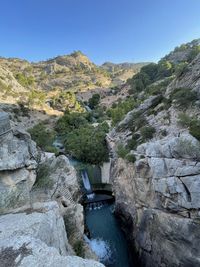 Scenic view of river amidst mountains against clear sky