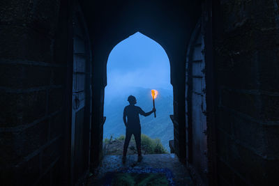 Rear view of man standing in middle of door 