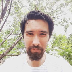 Portrait of young man against trees