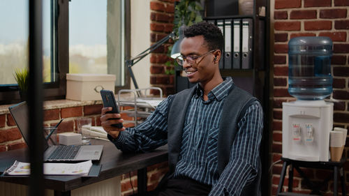 Smiling businessman talking on video call at office