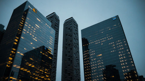 Low angle view of skyscrapers against clear sky at night