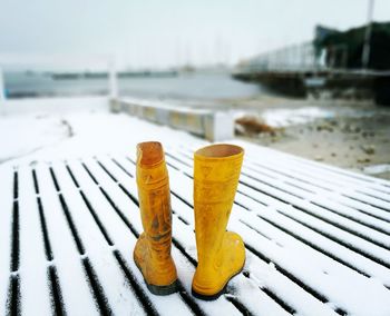 Yellow boots on snow covered bench