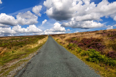 Empty road along countryside landscape