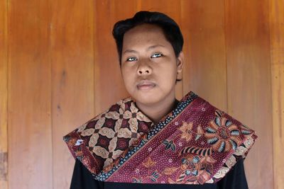 Portrait of serious young woman wearing traditional clothing at home