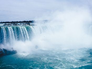 Scenic view of waterfall against sky