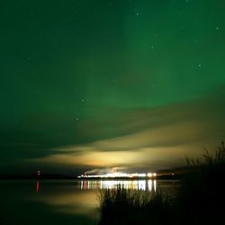 Scenic view of lake against sky at night