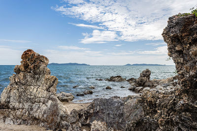 Rock formation on beach against sky