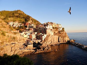 Scenic view of sea and buildings against clear sky