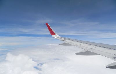 Airplane flying over clouds against sky