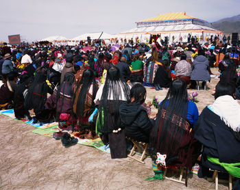Group of people in traditional clothing against sky