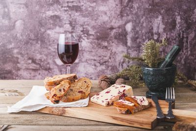 An assortment of various types of cheese with wine, and grapes, shot from above on a dark rustic