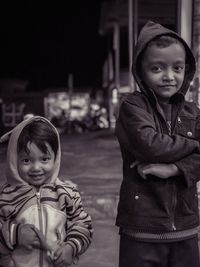 Portrait of siblings standing on road during winter