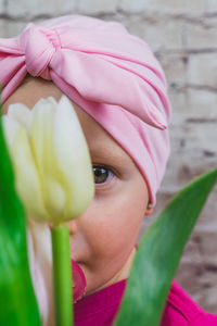 Close-up portrait of a girl holding pink flower