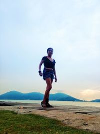 Full length of woman standing on mountain against sky