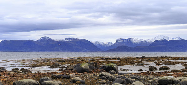 Scenic view of sea and mountains against sky