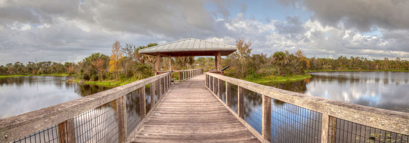 Sunset over gazebo on a wooden secluded, tranquil boardwalk along a marsh pond in freedom park