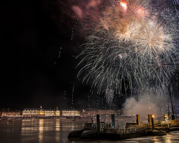 Firework display over river at night