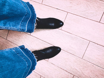 Low section of woman standing on wooden floor