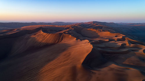 Scenic view of desert against sky during sunset