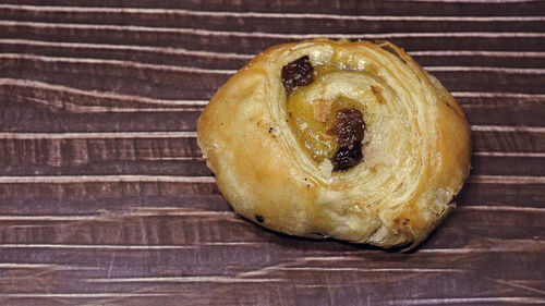 Traditional raisin swirl, pain aux raisins from france. closeup view on white wooden background