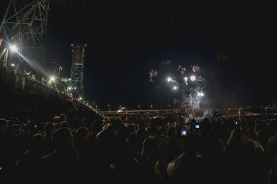 Crowd at music concert against sky at night