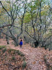 Rear view of woman walking on field