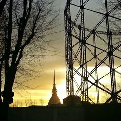 Low angle view of bare trees against sky at sunset