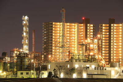 Illuminated cityscape against sky at night