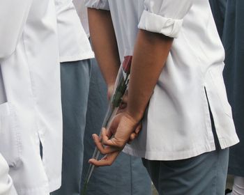 Midsection of man holding rose