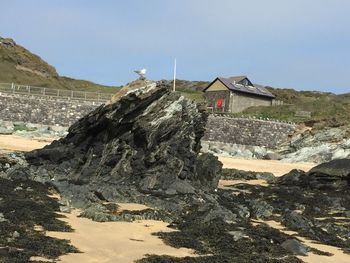 Buildings by rock formation against sky