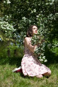 Portrait of young woman standing against trees